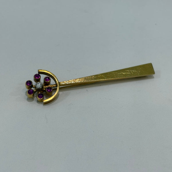 Goldbrosche mit Brillant umgeben von Rubinen